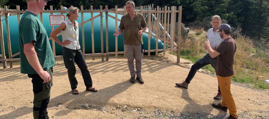 Nationalparkleiter Dr. Roland Pietsch (Mitte) erläuterte das mobile Löschwasserkissen am sogenannten Goethebahnhof. Dieser Behälter ist während der Waldbrandsaison mit rund 100.000 Litern Löschwasser gefüllt. Foto: Tim Mann